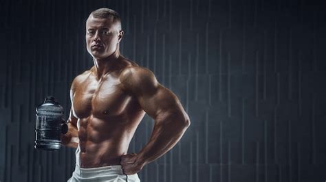 Premium Photo Fit Man At Workout In Gym With Shaker On Dark Background