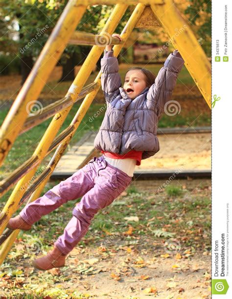 This little boy was washing his dad's car when his pants suddenly fell down. Smiling Girl Hanging On Climbing Frame Stock Photos - Image: 34376613