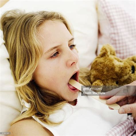 Young Girl Getting Her Throat Checked With A Tongue Depressor High Res