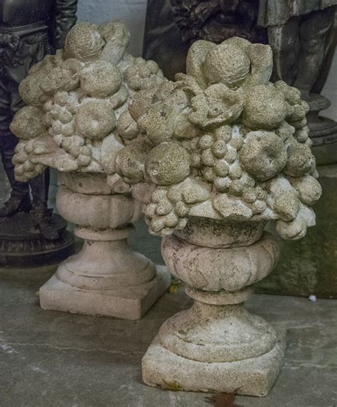 GARDEN FINIALS, a pair, composite stone, modelled as urns bearing fruit ...