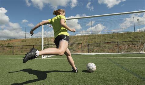 girl kicking soccer ball into goal farm and dairy