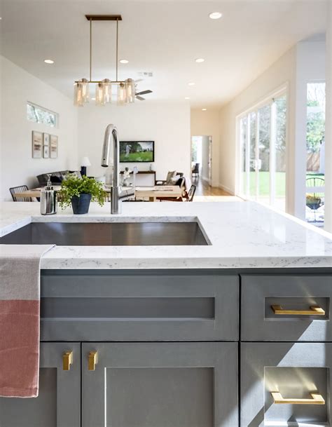 Discover inspiration for your kitchen remodel or upgrade with ideas for storage, organization, layout and decor. Grey kitchen cabinets with brass fixtures and quartz ...