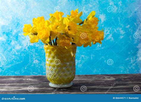 Bright Yellow Narcissus Flowers Bouquet In A Yellow Glass Vase Stock