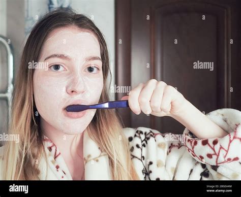 A Young Girl With Cream On Her Face Brushes Her Teeth With A Toothbrush Morning Toilet