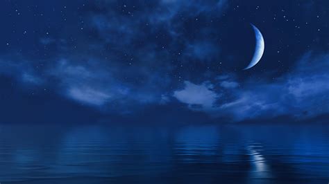 Half Moon In Starry Night Sky Above Ocean Surface Stock Photo