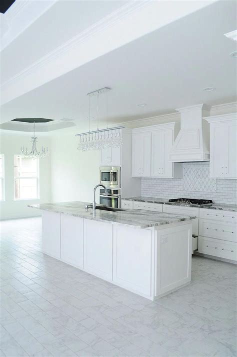 Marble Look Tile Flooring In A White Kitchen With Shaker Cabinets And