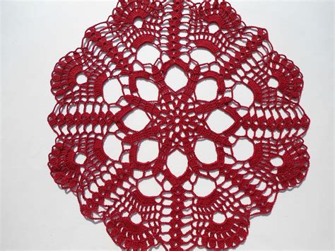 A Crocheted Doily Is Shown On A White Surface