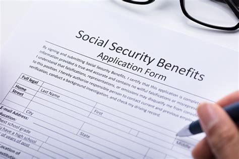 Person Filling Social Security Benefits Application Form Stock Photo
