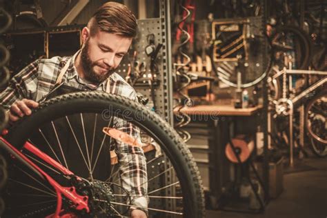 Stylish Bicycle Mechanic Doing His Professional Work In Workshop Stock