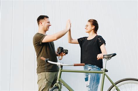 Side View Of Photographer And Cute Model Giving High Five Each Other