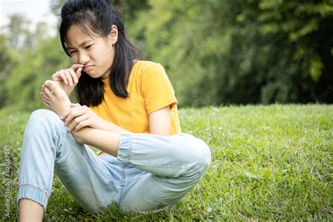 Unhappy Asian Female Teen Is Sniffing Her Feet Smellhold Her Foot In