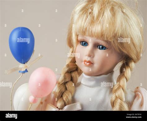 vintage porcelain doll girl blonde with braids with blue eyes in a light dress with white pink