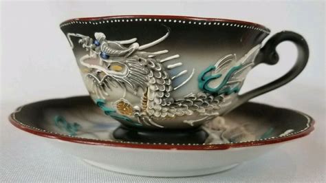 A Cup And Saucer With A Dragon On It