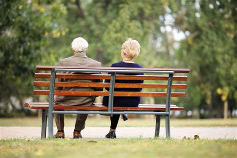 Пожилая пара на скамейке в парке фото