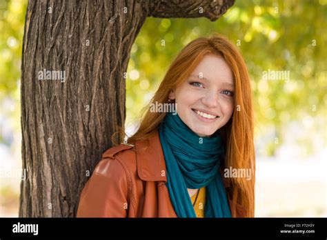Young Positive Smiling Redhead Woman In Leather Jacket And Scarf Posing