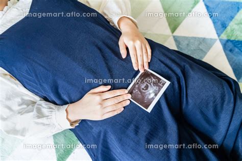 赤ちゃんのエコー写真を持った妊婦の写真。妊娠中のイメージ。 [167214693] イメージマート