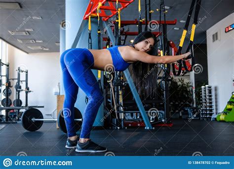 Beautiful Slim Fitness Girl Doing Exercises With A Suspension Straps In