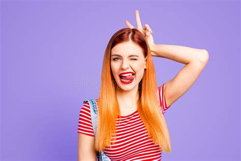 Nice Fool Red Straight Haired Young Girl Showing Tongue Out And Horns