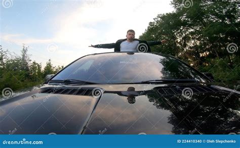 Happy Funny Man Standing Out Of Car Sunroof And Showing Joyful Or Crazy
