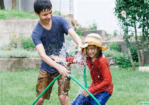 Brothers Having Water Fight With Hose Stock Image Everypixel