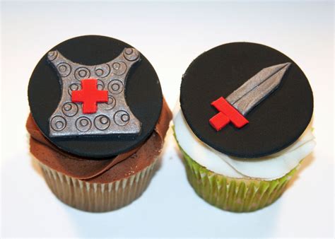 Two Cupcakes Decorated With Black Frosting And Red Fondant One Has A