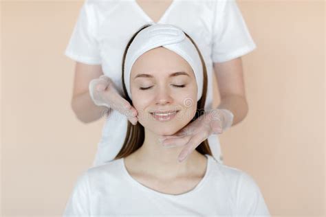 A Happy Woman With A White Bandage On Her Head Is Having A Facial Massage Close Up Of A Woman