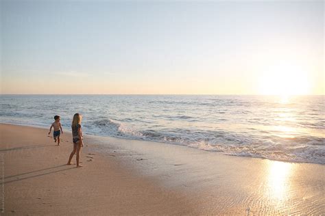 Happy Kids Playing On Sandy Beach At Sunset By Stocksy Contributor