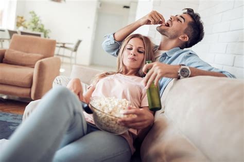 Premium Photo Couple Watching Tv And Eating Popcorn