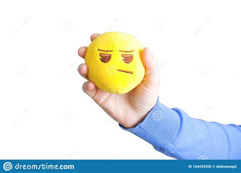 Yellow Round Soft Toy Sad Emoticon In The Hand Of A Caucasian Girl