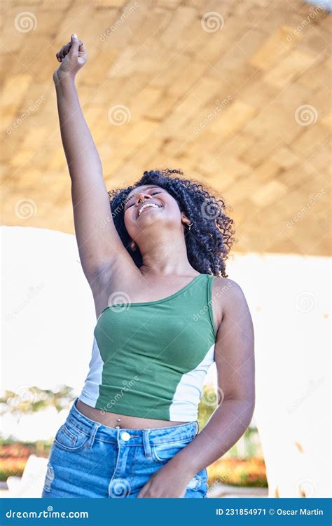 Curly Haired Latina Teenager With Her Fist Raised In Victory Or Protest