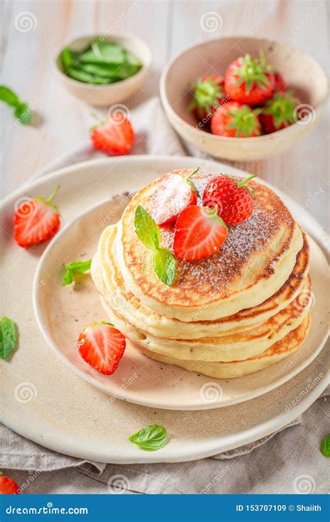 Homemade American Pancakes With Powdered Sugar And Sweet Strawberries