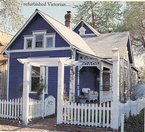 Blue Victorian Cottage House With White Picket Fence And Porch For