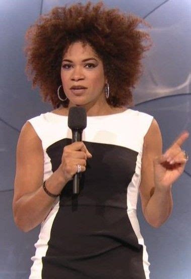 A Woman Holding A Microphone In Her Right Hand And Pointing To The Side
