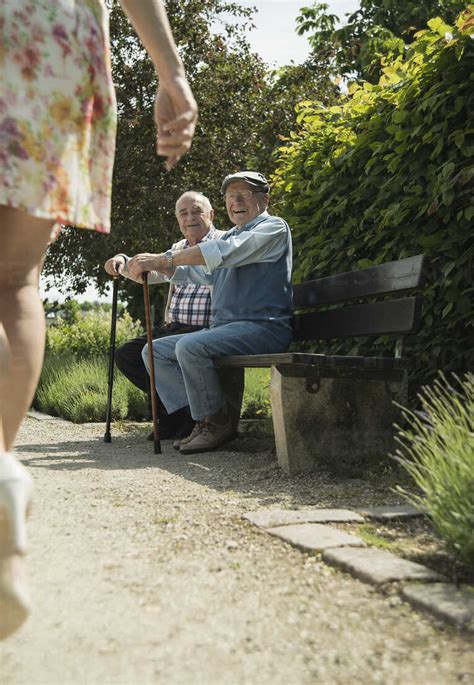 Zwei Alte Männer Sitzen Auf Einer Parkbank Und Beobachten Die Beine Einer Vorbeigehenden Frau