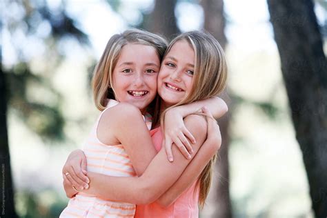 Twin Sisters Hugging Each Other Outdoors By Dina Marie Giangregorio