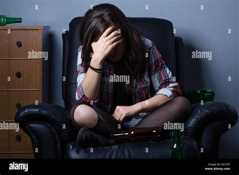 Traurige Betrunken Frau Auf Sessel Mit Leeren Flaschen Stockfotografie