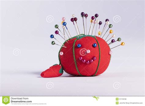 Red Pin Cushion With Smily Face On White Background Stock