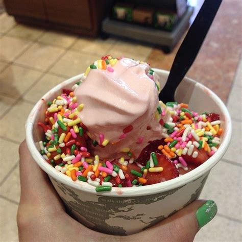 A Person Holding A Cup With Ice Cream And Sprinkles