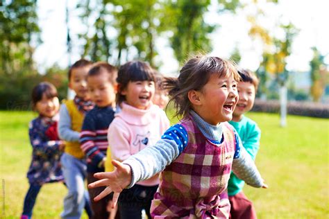 Happy Asian Kids Playing Outdoor In The Park By Stocksy Contributor