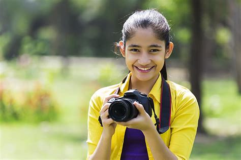 Happy Young Girl Cameraman Holding Digital Camera And Taking Photo At Park