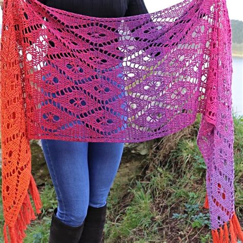 A Woman Wearing A Pink And Orange Crocheted Shawl With Fringes On It