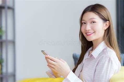 Asian Beautiful Woman With Long Hair Who Wears Shirt Sits On Yellow