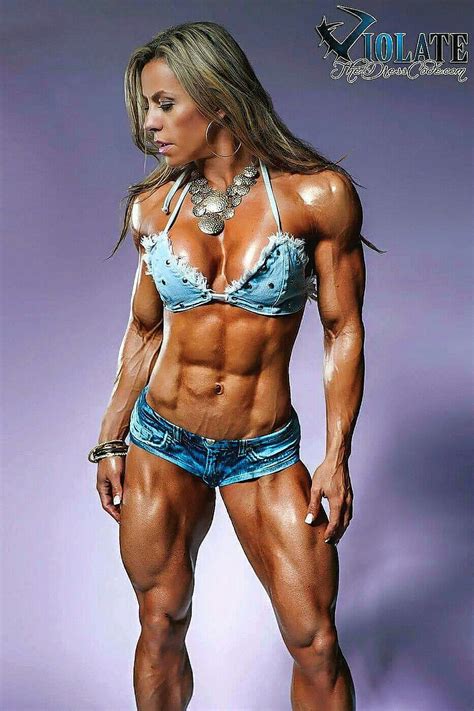 A Female Bodybuilding Competitor Posing For The Camera With Her Hands On Her Hips And Showing Off