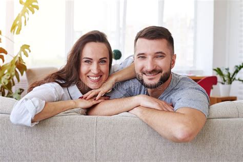 Gorgeous Wife And Husband Spending Free Time Relaxing On Sofa Stock