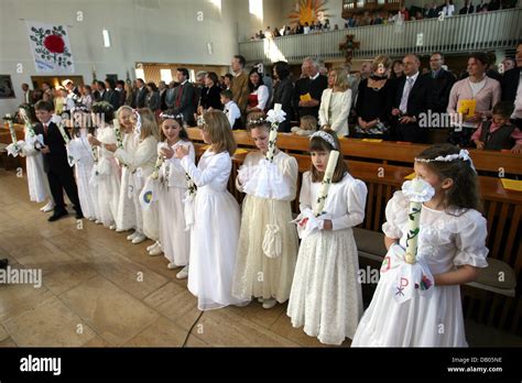 Girls In Traditional Dresses Hold Candles During The First Communion