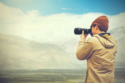 Travel Photographer Journalist Holding A Dslr Camera In Mountain