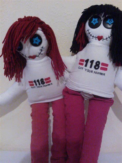 Two Dolls With Red Hair And Blue Eyes Sitting Next To Each Other On A White Surface