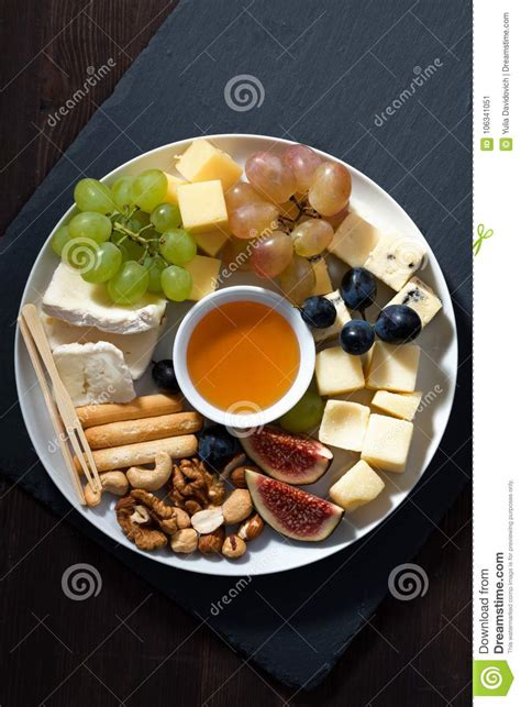 Plate Of Cheeses Snacks And Fruits On A Dark Background Stock Image