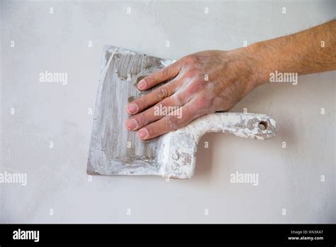 Plastering Man Hand With Plaste And Plaster Spatula Trowel In Wall