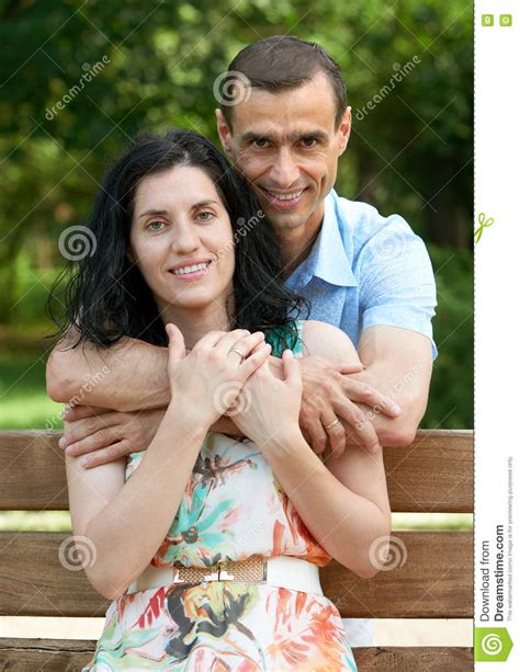 Romantic Couple Sit On Bench In City Park Summer Season Adult Happy